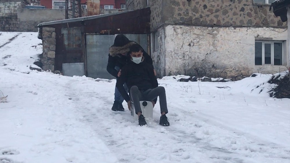Kars’ta kartopu oynadılar, bidona binerek kaydılar